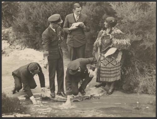 Charles Kingsford Smith, H.A. Litchfield and guide Bella, with T.H. McWilliam and Charles Ulm testing water temperature of hot pools, at Rotorua, New Zealand, September 1928 [picture] / J.F. Louden