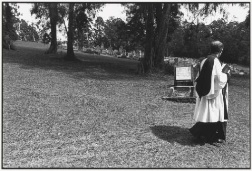 Clergyman walks past the grave of Black Jimmy, Bellingen, New South Wales, 2003 [picture] / Jon Rhodes