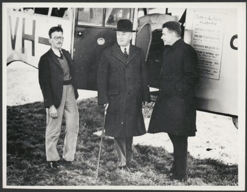 Portrait of Charles Ulm, Prime Minister J.A. Lyons and an unidentified man in front of Faith in Australia, Avro X monoplane VH-UXX, 1934 [picture]