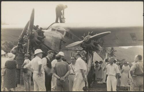 Charles Ulm with government officials and onlookers in front of Faith in Australia, Avro X monoplane VH-UXX, on completion of first official Australia - Papua-New Guinea airmail flight, Port Moresby, 26 July 1934, [2] [picture]