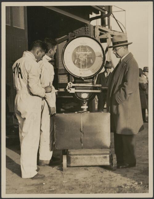 Luggage being weighed by Australian National Airways staff, with passenger looking on, ca. 1931 [picture] / J.T. Harrison