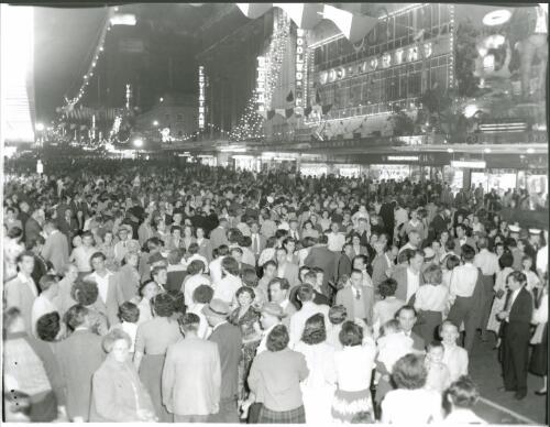 Thousands of people in Bourke Street late at night looking at the city's sparkling decorations during the Olympic Games, Melbourne, 22 November, 1956 [picture] / Bruce Howard
