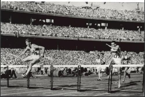 Glenn Davis of the United States of America leading in the 400 metre hurdles finals, Melbourne Cricket Ground, 24 November, 1956 [picture] / Bruce Howard