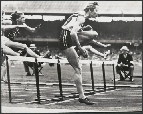 Shirley Strickland of Australia clears the last hurdle ahead of the field in the women's 80 metres hurdle final, Olympic Games, Melbourne Cricket Ground, Victoria 1956 [picture] / Bruce Howard