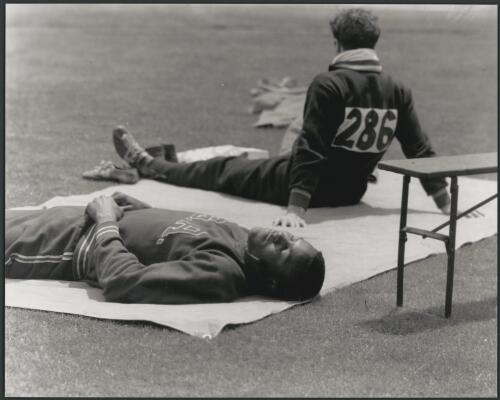 Resting between decathlon events at the main stadium, Melbourne Cricket Ground during Olympic Games, Victoria, November, 1956 [picture] / Bruce Howard