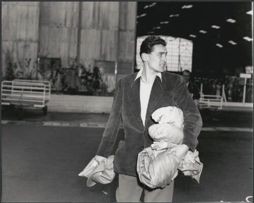 A Hungarian athlete takes a last look at the waving crowd before boarding the team's aircraft, Essendon Airport, Victoria, 1956 [picture] / Bruce Howard