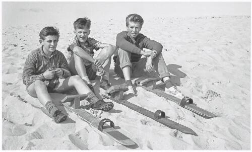 Three boys with their sand skis at the sand dunes, Cronulla, New South Wales, ca.1963 [picture] / Jeff Carter