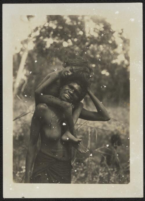 Portrait of an Aboriginal mother with her child on her shoulders, Arnhem Land, Northern Territory, 1928 [picture] / Donald Mackay