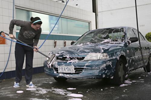 Young woman washing her car at a self service car wash, Surrey Hills, Victoria, 2007 [picture] / June Orford