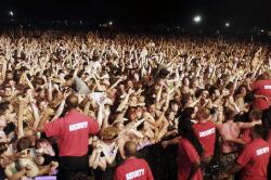 Crowd-surfers in the mosh pit and security guards near the edge of the ...