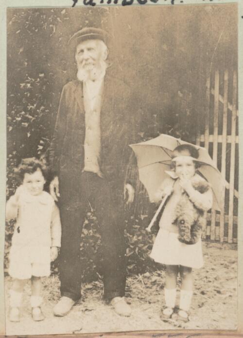 Elderly man standing with two little girls, approximately 1920 / W. A. S. Dunlop