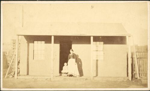 Woman and nfant on the veranda of a rendered cottage with corrugated iron roof, Hill End, New South Wales, ca.1872 [1] [picture]