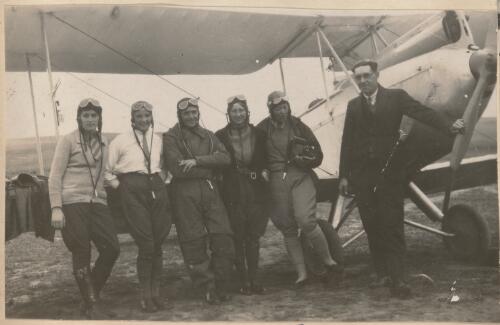 Tommy Cunningham and four pilots leaning against the wing of a biplane at Goulburn Aero Club, Goulburn, New South Wales, November 1930 / W. A. S. Dunlop