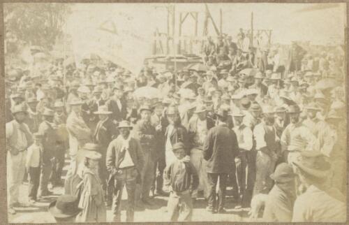 Crowd waiting for the laying of the foundation stone ceremony for the girls' wing addition to the Public School, featuring the banner of the Temperance and Friendly Society, on the afternoon of 1st April 1872, Clarke Street, Hill End, New South Wales, 1872 [picture]