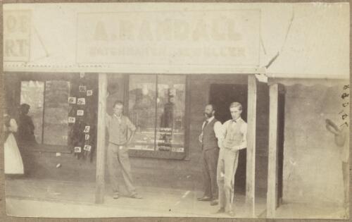 Three men outside the shop of A. Randall, watchmaker and jeweller, next door to Condell's Boot Mart on the left, Clarke Street, Hill End, New South Wales, ca.1872 [picture]