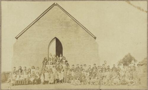 Schoolchildren and teacher outside brick Sacred Heart Catholic Church, corner of Denison and Thomas Streets, Hill End, New South Wales, ca. 1872 [picture]