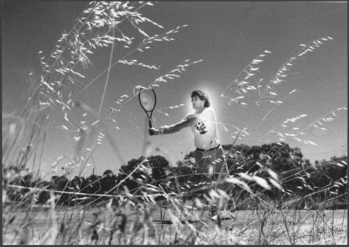 Australian tennis star Paul McNamee plays a game of tennis on his home court at Tarnagulla in central Victoria,1986 [picture] / Bruce Howard