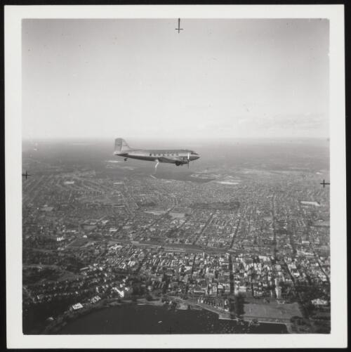 MacRobertson Miller Aviation Douglas DC-3 airliner VH-MMK 'Kimberley' in flight above Swan River and esplanade, Perth, ca. 1960 [picture]
