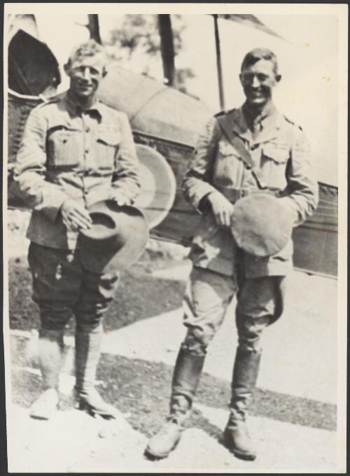 Horrie Miller (left) and Paul McGuiness in military uniforms in front of a biplane, ca. 1918 [picture]
