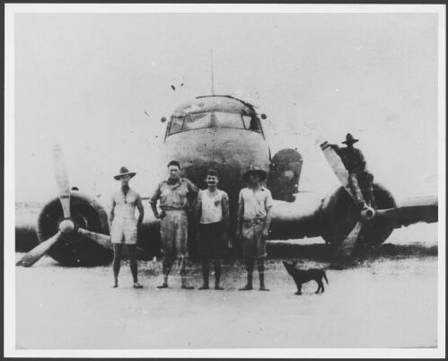 Investigating party standing in front of crashed Netherlands East Indies KLM Dakota DC-3 passenger transport PK-AFV 'Pelikaan' at Carnot Bay, Lieutenant Laurie O'Neil (second from left), 'Diamond' Jack Palmer (third from left) and Warrant Officer Gus Clinch (fourth from left), Western Australia, March 1942 [picture]