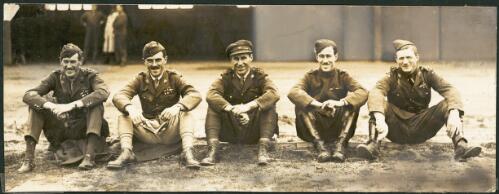 Australian Flying Corps Flight Lieutenants MacInerney, J. Turnbridge, F. Shepherd, S. Oakes and H.C. Miller (from left to right) sit on the ground in a row at Point Cook after the First World War, Victoria, ca. 1919 [picture]