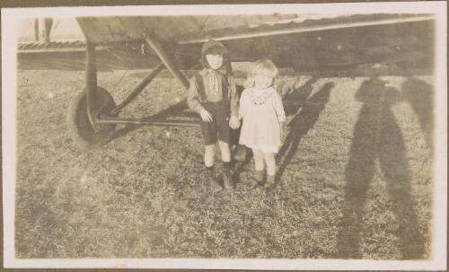 Young boy and girl stand holding hands in front of Horrie Miller's de Havilland DH6 biplane C372 'The Clutching Hand', South Australia, ca. 1919 [picture]