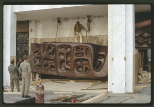 Installing the Tom Bass lintel sculpture over the main entrance to the National Library of Australia, Canberra, Australian Capital Territory, May 1969, 3 [transparency] / Kevin Goodridge