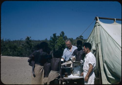 Aboriginals receiving their food ration, Yirrkala, Northern Territory, 21 August 1948 [transparency] / Robert Miller