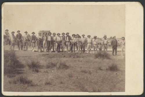 Line-up of workmen holding picks and shovels at Stuart Creek Station, South Australia, ca. 1897 [picture]