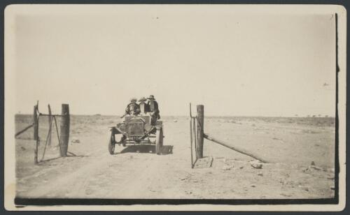 Model T Ford passing through the gate of a boundary fence, Stuart Creek, South Australia, ca. 1925 [picture]