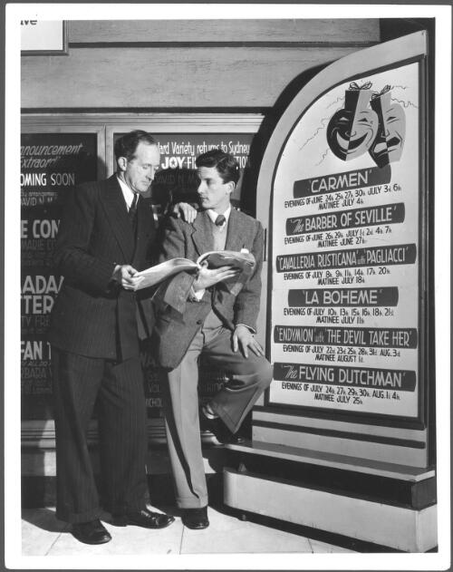 Robin Lovejoy (right) discusses the score of Endymion with composer John Antill in the foyer of the Tivoli Theatre, 1953 [picture] / News & Information Bureau, Dept. of the Interior