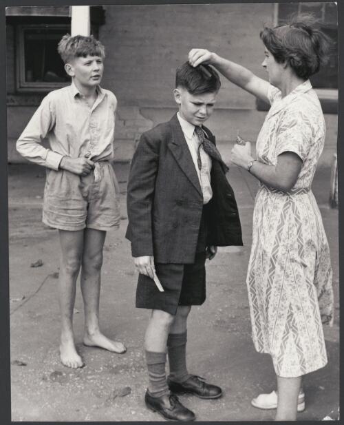 A woman combs a boy's hair at Kilmany Park Boys Home, Sale, Victoria, ca. 1955 [picture] / Jeff Carter