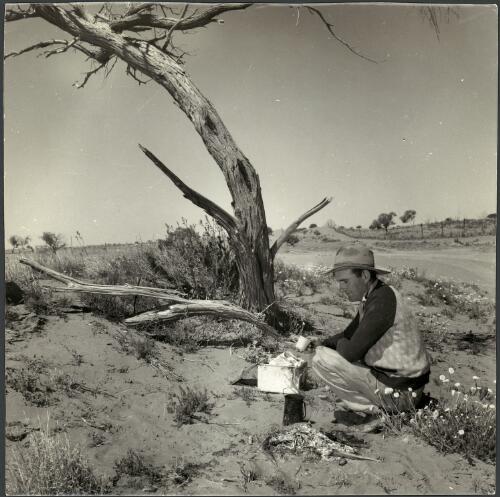 A boundary rider boils a billy near the wild dog fence, Australia, 1958 [picture] / Jeff Carter