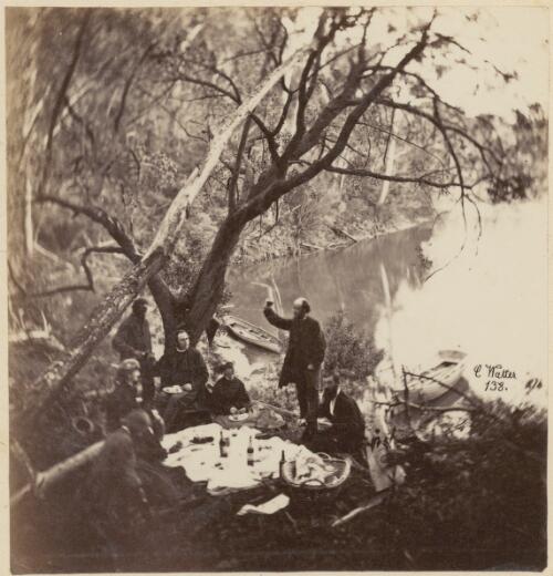 Picnic party drinking and eating under the trees beside a river, with one man proposing a toast, New South Wales, ca. 1869 [picture] / Charles Walter