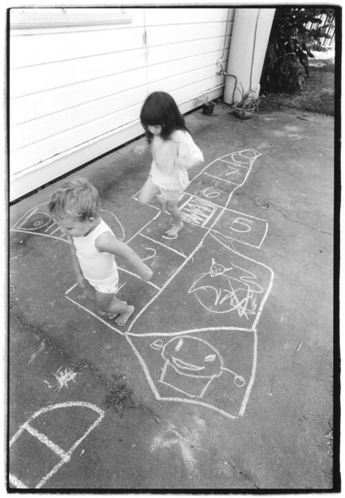 Ruby Gostelow and friend play hopscotch on backyard patio, Woodford, New South Wales, 2000 [picture] / P. Gostelow