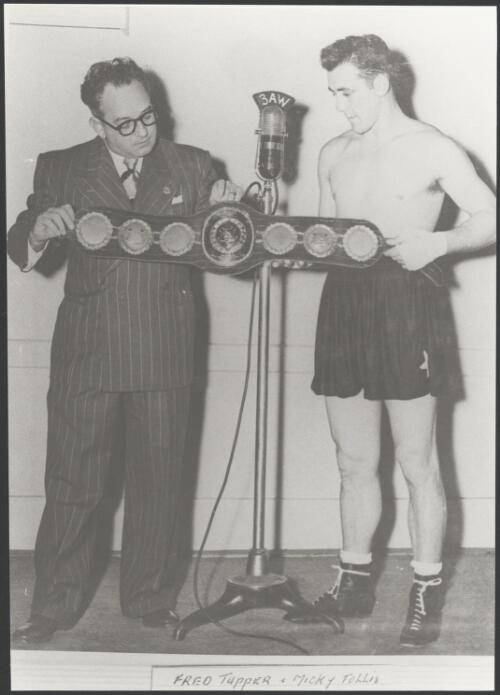 Mickey Tollis recieving a championship belt from Fred Tupper [picture]