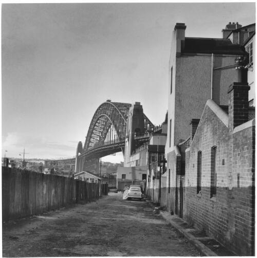 The Sydney Harbour Bridge from a side street, 1952 [picture] / Jeff Carter