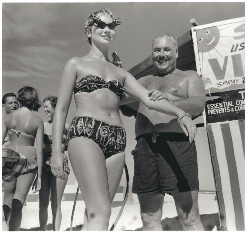 John Paterson applies Mutton Bird oil as a sun tanning aid to a bather on the Gold Coast, 1957 [picture] / Jeff Carter