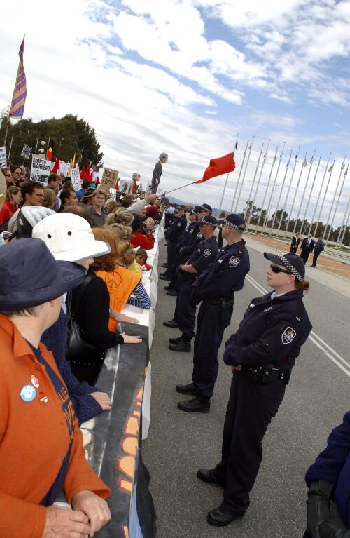 [Police stand in front of demonstrators at Parliament House in Canberra during the visit of President Bush, 23 October 2003] [picture] / Loui Seselja