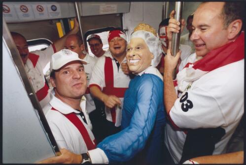 English Rugby supporters, one dressed as HRH Queen Elizabeth II, in a train carriage travelling to the Rugby World Cup final in Sydney, November 2003 [picture] / Ben Rushton