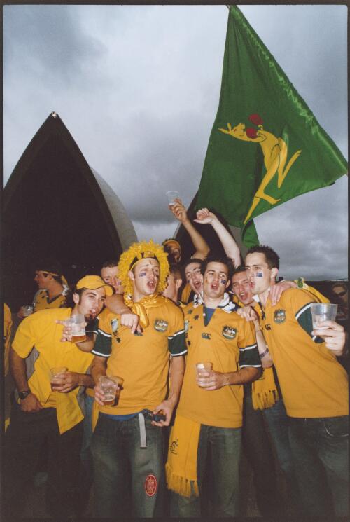 Young Australian guys on the steps of the Opera House before the live broadcast of the Rugby World Cup final in Sydney begins, November 2003 [picture] / Ben Rushton