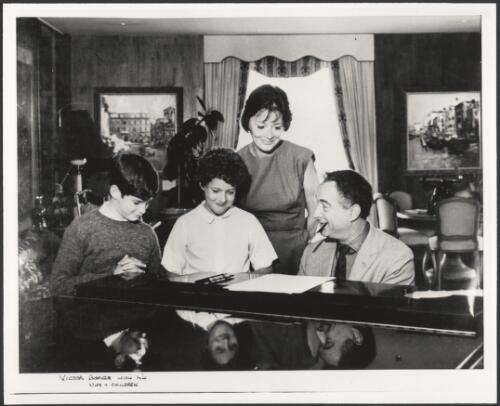 Victor Borge with his wife Sana [i.e. Sanna]and children, Sana [i.e. Sanna] and Ronald,[around a piano, 195-?] [picture]