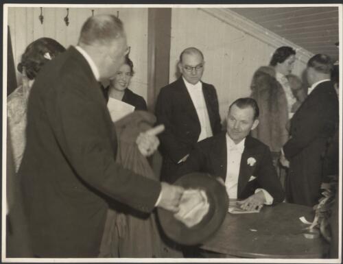 [Lawrence Tibbett seated at a table with Frank Tait (?) standing behind him, 1938?] [picture]  / S.J. Hood