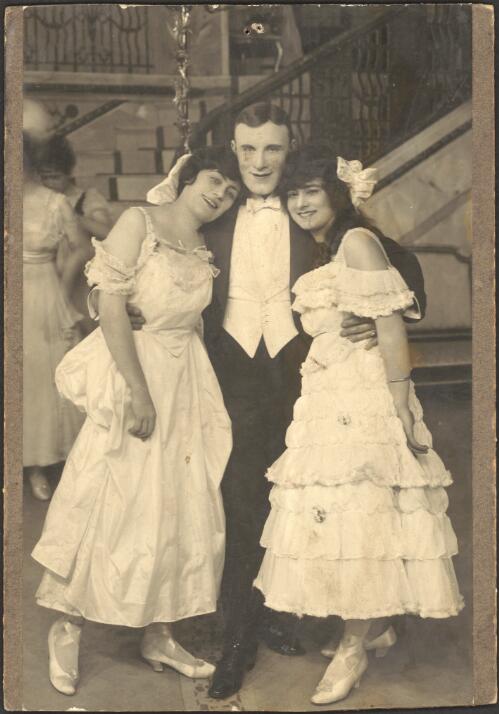 [Male performer in tuxedo flanked by two female performers in ruffled dresses and with bows in their hair, for J.C.Williamson production, all unidentified, 19--?] [picture]