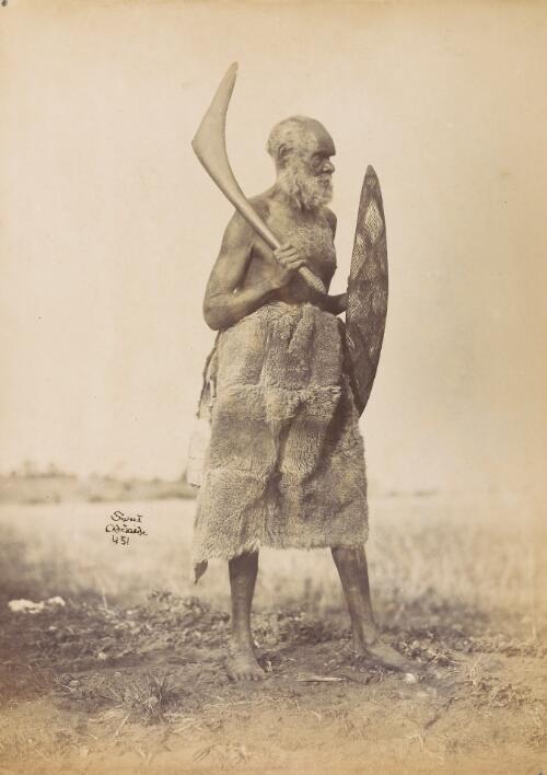 Portrait of unidentified Aboriginal man wearing skins, holding shield and boomerang, ca. 1870s? [picture] / Sweet