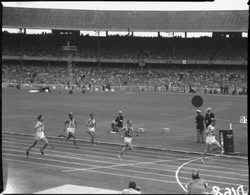[The finish of heat 2 of the men's 200 metres race which no. 68 Karl-Friedrich Haas (Germany) won, followed by no. 62 Janecek (Czechoslovakia), no.6 Winston (Australia) third, and no. 71 Milkha Singh (India) and no. 25 Ushio (Japan), Olympic Games, Melbourne, 26 November 1956] [picture]