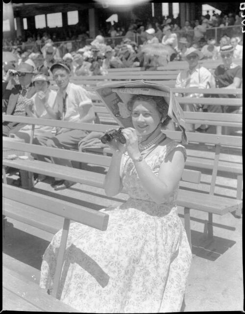[Woman spectator with binoculars and an elaborate sunhat made of newspaper, Olympic Games, Melbourne, 22 November 1956] [picture]