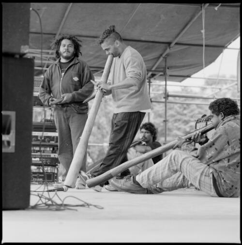 Group of men playing didgeridoos at the Australia Day ceremony at the Aboriginal Tent Embassy in front of Old Parliament House, Canberra, 26 January 1998 [picture] / Loui Seselja