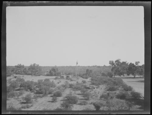 Windmill and tanks in the house paddock at Minilya Station, Western Australia, 1919 / Michael Terry