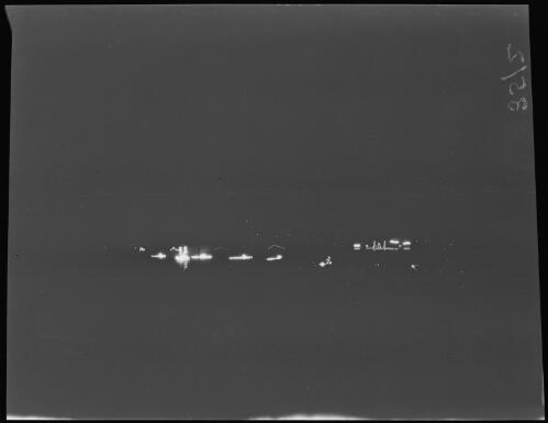 Four submarines and HMAS Brisbane illuminated at night during the Royal visit, Sydney Harbour, June 1920 / Michael Terry